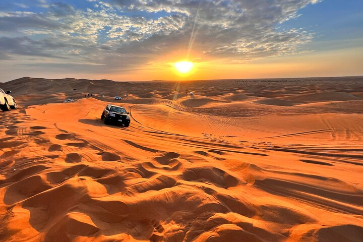 Experience the stunning golden sands and breathtaking sunrise of Dubai's desert where 4WD dune-bashing and sandboarding adventures await blending nature with unforgettable moments of exploration.
